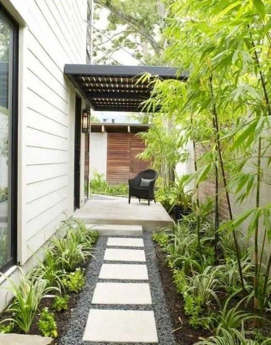 A low maintenance side yard with pebbles, tiles, greenery and bamboo is a lovely idea for a modern home