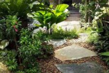 42 a lush side yard with pebbles, irregular stones, lots of greenery and blooms and some trees around