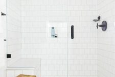 53 a neutral bathroom with a white square tile shower, a bold tile floor, black fixtures and a wooden stool welcomes in