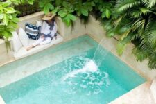 54 a wonderful tropical backyard all clad with sandy shaded tiles and with a small pool with a waterfall