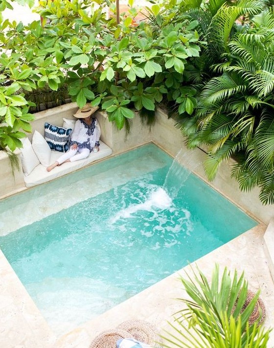 a wonderful tropical backyard all clad with sandy shaded tiles and with a small pool with a waterfall