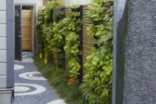 57 a small and narrow side yard with a vertical garden with lights and a lovely stone path is a super chic and bold idea