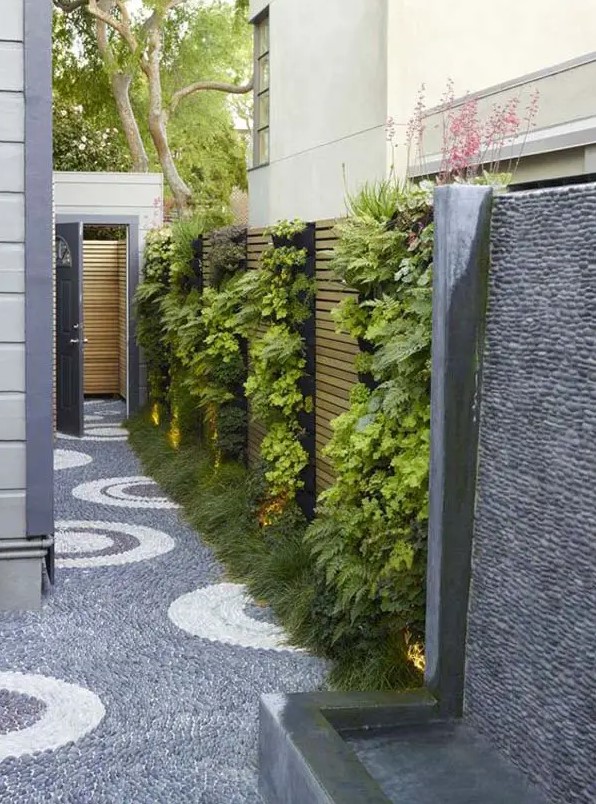 a small and narrow side yard with a vertical garden with lights and a lovely stone path is a super chic and bold idea