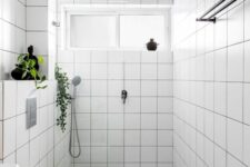 59 a small neutral bathroom with white square tiles, a green and white tile floor, a window, neutral appliances and black touches