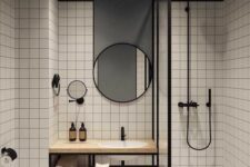 60 a stylish contrasting modern bathroom with white square tiles and a grey ceiling and wall, a shower, a vanity, round mirrors and black fixtures