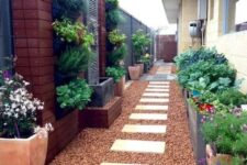 61 a stylish and bright side yard with pebbles and pavements, potted greenery and blooms and a vertical garden
