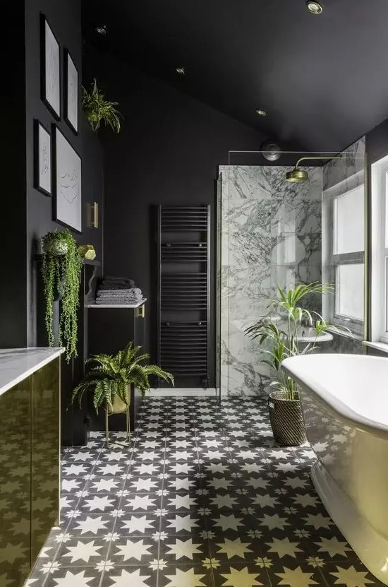 a stylish modern bathroom done with matte black walls, a gold vanity, gold planters and accessories plus cool monochrome tiles