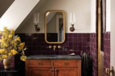 62 a vintage attic bathroom with a terracotta tile floor, burgundy square tiles on the walls, a stained cabinet and brass touches