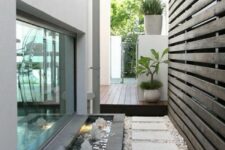 63 a stylish little side yard with pebbles, pavements and a cool modern fountain that adds a lovely sound to the space