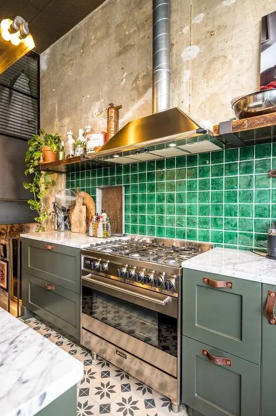 a stylish olive green kitchen with leather handles, a bold green tile backsplash and open shelves plus white stone countertops