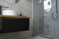 65 concrete-looking matte grey tiles cover the whole bathroom and make it modern and refined