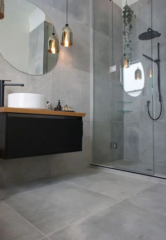 Concrete looking matte grey tiles cover the whole bathroom and make it modern and refined