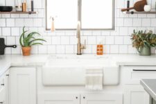 66 a white farmhouse kitchen with shaker cabinets, a white square tile backsplash, white countertops, open shelves and potted plants