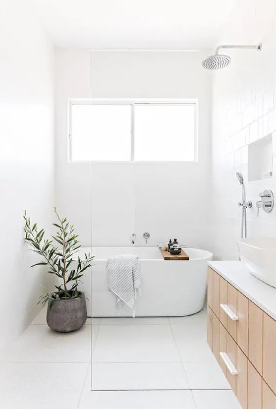a serene bathroom in neutrals, with square large scale tiles, a wood floating vanity, a niche shelf and a potted plant