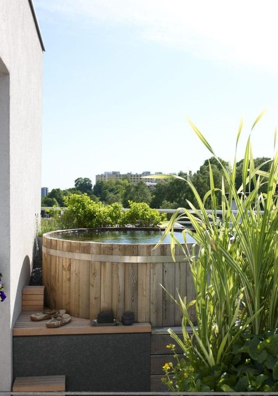 a small pool space with a stock tank pool clad with wood and with wooden ladders, with growing grasses is a lovely nook to refresh yourself