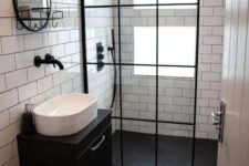 a tiny contrasting bathroom with windows in the shower, clad with white and black tiles, a black floating vanity and black touches here and there