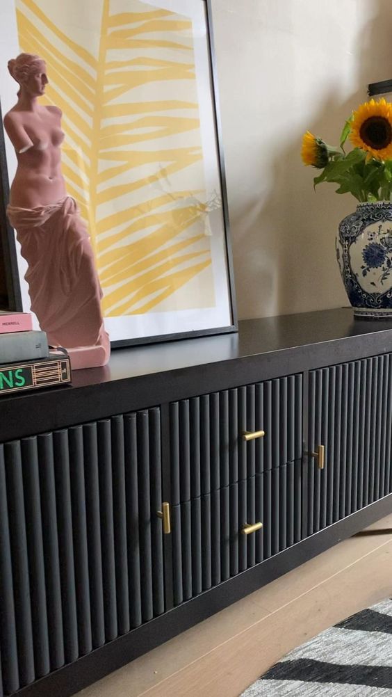 a beautiful black sideboard with black fluted panels and gold handles, with bright and catchy decor is amazing for a modern space