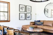 05 a mid-century modern living room with a brown leather sectional, a round coffee table, black chairs, a boho printed rug