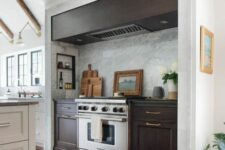 06 a modern farmhouse kitchen in white, with a large niche with dark-stained cabinets and a hood, some small shelves for condiments and oils