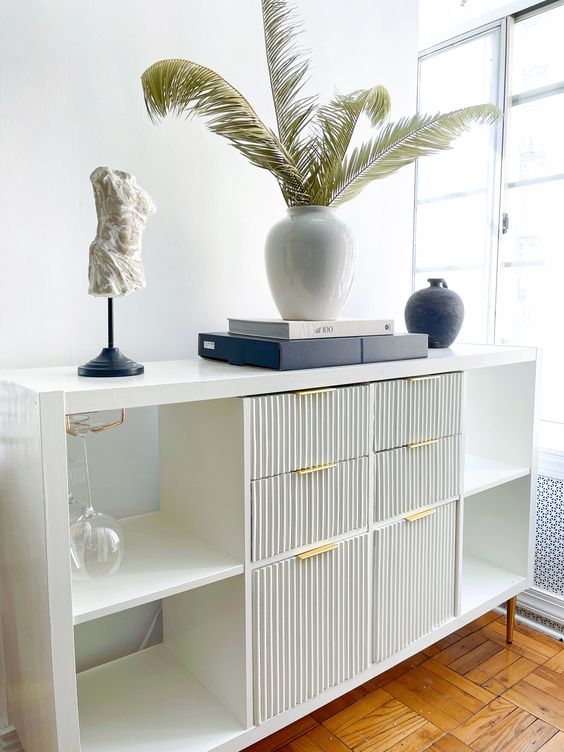 a chic fluted and open storage compartment piece with books, decor and vases is a lovely idea for a modern space
