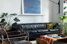 11 an elegant mid-century modern living room with a black leather sofa, black chairs, curved plywood furniture and a potted plant