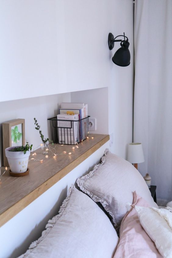 a Scandinavian bedroom with a long and narrow headboard niche used for decor and storage is a lovely and airy space