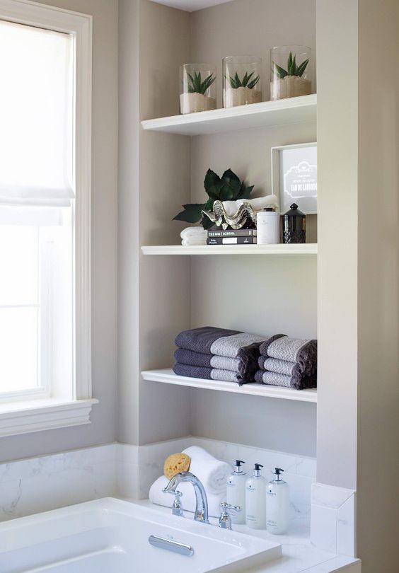 a large niche with shelves used for storing various things and decor is a lovely idea for a modern bathroom, it looks cool