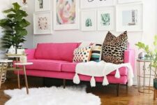 17 a lovely modern living room done in neutrals, witha pink sofa, an airy gallery wall, white textiles, potted plants and some tables
