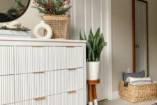 18 a fluted IKEA Hemnes hack with gold handles, with some vases, potted plants and decor is a perfect match for a modern space
