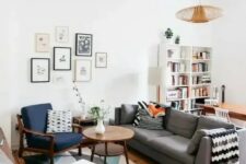 18 a mid-century modern living room with a bold printed rug, a grey sofa, a navy chair and a white stool, a cool gallery wall