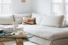 27 a neutral living room with a linen sectional and linen pillows, a coffee table with decor and books