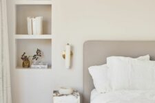 27 a neutral serene bedroom with a bed, a marble nightstand and niche shelves used fro storage and decor