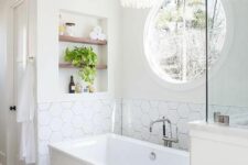 30 a modern neutral bathroom with white walls, printed and hexagon tiles, a rectangular tub, a niche with shelves and some lovely decor