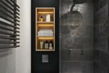 31 a moody black bathroom with stone-inspired tiles, a wall shelf with lights, a shower space