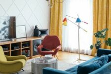 34 a bright mid-century modern living room with a stained storage unit, a coral and mustard chair, a navy sofa, a side table and colorful lamps