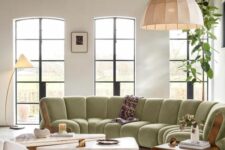 35 a refined living room with tall windows, a light green cotton sectional, a duo of coffee tables, a couple of chairs