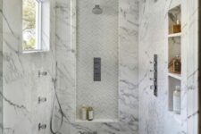 44 a shower space clad with marble tiles, with niches used for storing things that are necessary for washing, a window for naturla light