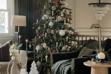 45 a beautiful living room with a black chair and a white sofa, a fluted coffee table and a round one, a crystal chandelier and a Christmas tree