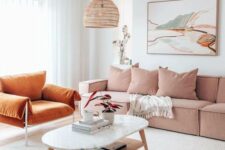 45 a bright living room with a pink olefin sectional, a rust-colored chair, a tiered coffee table and a bold artwork