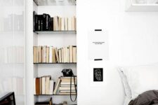 46 a Scandinavian bedroom with a bed and black and white bedding, a nightstand, a niche with bookshelves, some artwork