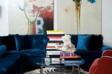 49 a bright living room with a navy sectional, a red chair, a clear glass coffee table, bold artwork and a zebra print rug is amazing