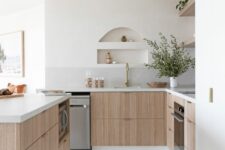 49 a serene contemporary kitchen with stained lower cabinets, stone countertops, open shelves, small niches over the sink that are used for storage