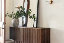 50 a cool stacked reeded console table with an oversized mirror, a planter with greenery and a sconce is a cool idea
