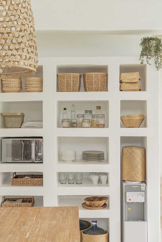 a whole wall of niches that are an alternative to a pantry, with appliances, baskets, porcelain and mugs is a very creative idea