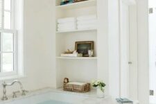 60 a neutral airy bathroom with a bathtub and niche shelves by its side is a cool idea, there you can store anything you want