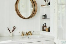 81 a white farmhouse bathroom clad with skinny tiles, with a large vanity, a niche with shelves to store mostly decor, a round mirror