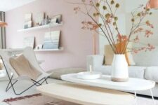 a beautiful Scandinavian living room with light pink walls, neutral furniture and branches in a vase plus a pink rug