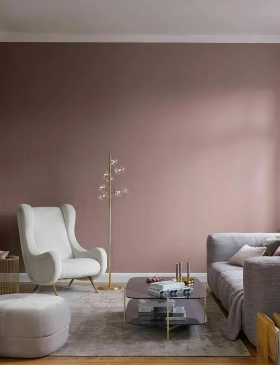 a beautiful mauve living room with a grey sofa, a creamy chair and a pouf, a grey rug and a two-tiered coffee table