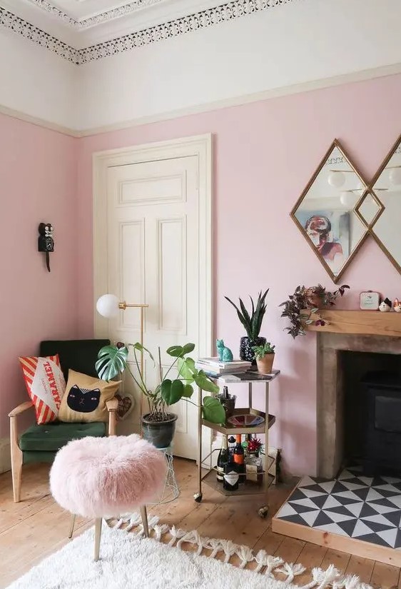 a cheerful pink living room with a green chair, a pink stool, a fireplace with tiles and potted plants