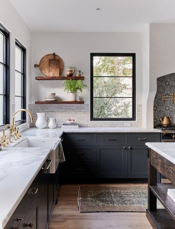 a chic dark grey farmhouse kitchen with white quartz countertops and a white marble tile backsplash, stained floating shelves and mixed metals